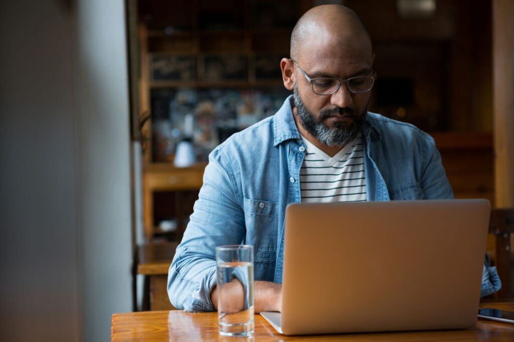 A man is using his laptop to compare quotes.