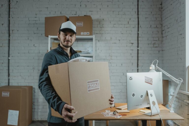 A professional mover is carrying a carton in the concept of a good man and van in Hammersmith.