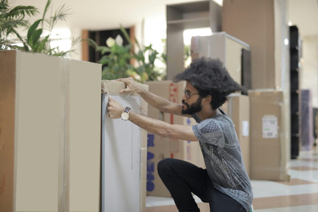 An employee is securely packing the office equipment for relocation.