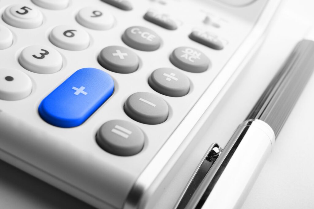 Cropped closeup of a calculator and a pen in the concept of budgeting for a relocation.