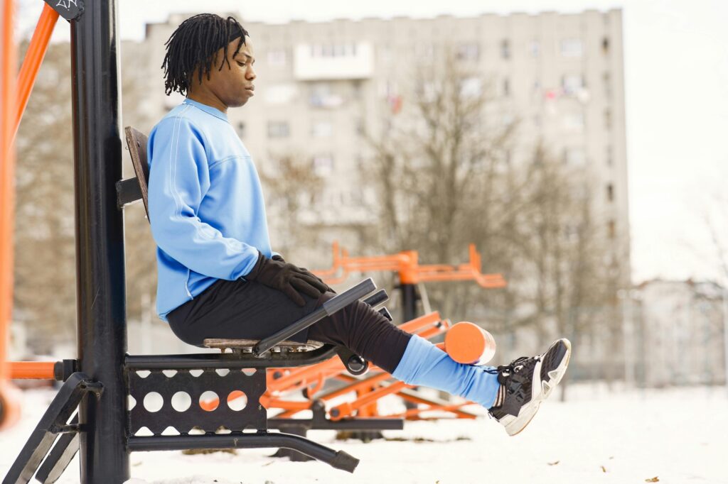 A young man in an outdoor gym during winter