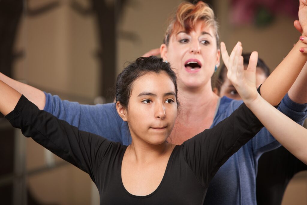 A dance teacher with students in a ballet class