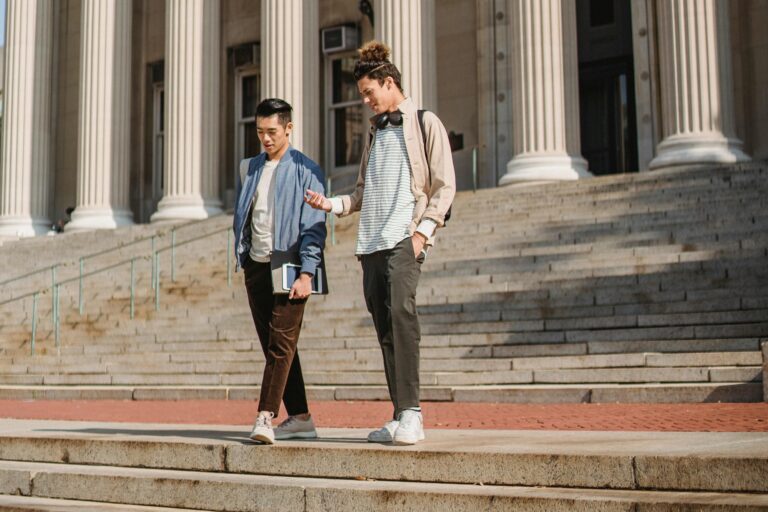 Two male students walking down the school's staircase in the concept of 'top schools in Hammersmith'.