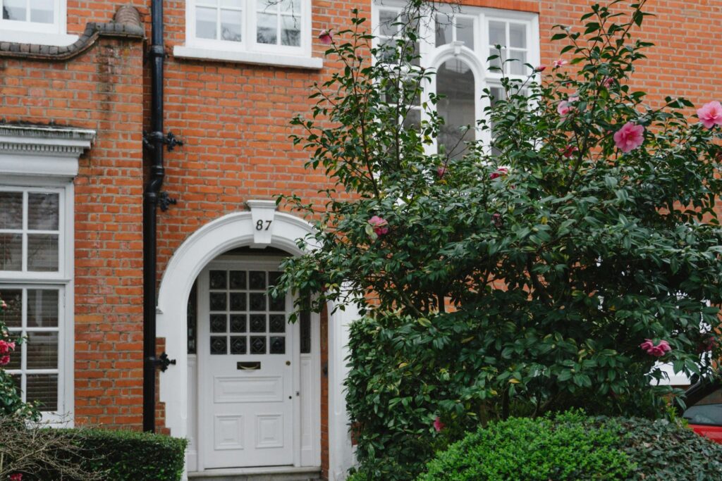 In front of a brick house in the concept of 'best affordable housing options in Hammersmith'.